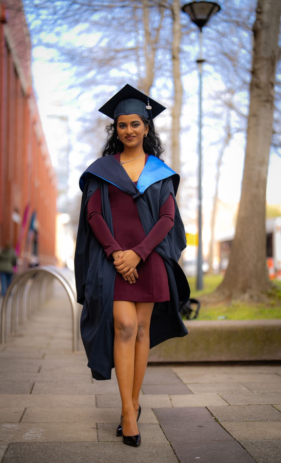 Graduate walking towards the camera in her gown