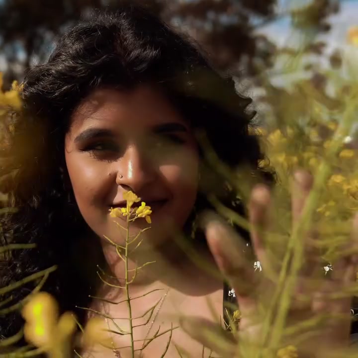 Portrait of a woman smiling among yellow canola flowers