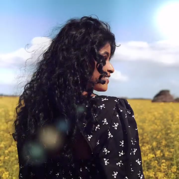 A woman looking over a canola field