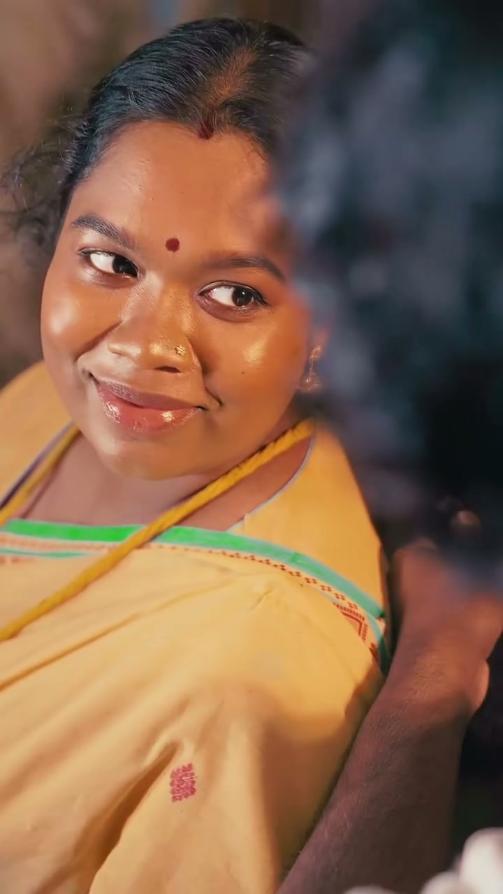 A mother-to-be smiling in a yellow saree