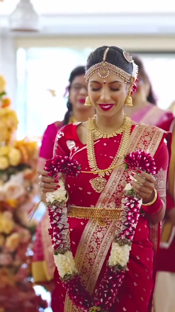 A bride in red silk holding her garland
