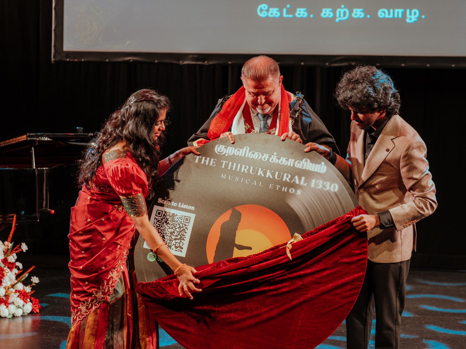 The record artwork being unveiled from under a red cloth
